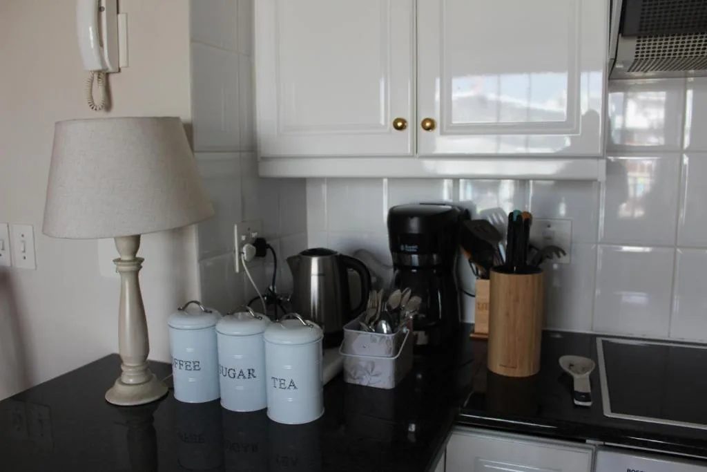 Kitchen counter with coffee canisters, kettle, and utensil holder