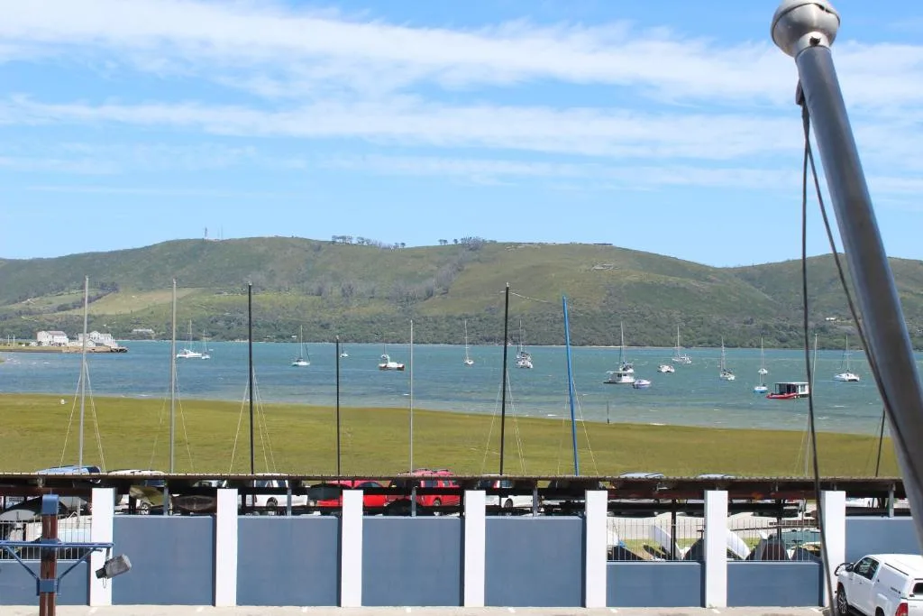 Scenic view of Knysna Heads lagoon with moored sailboats and green hills