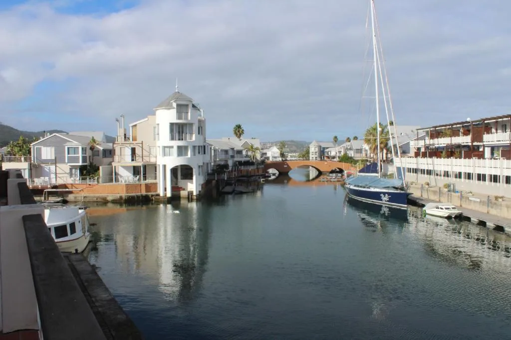 Waterfront canal with moored sailboats and charming waterside buildings