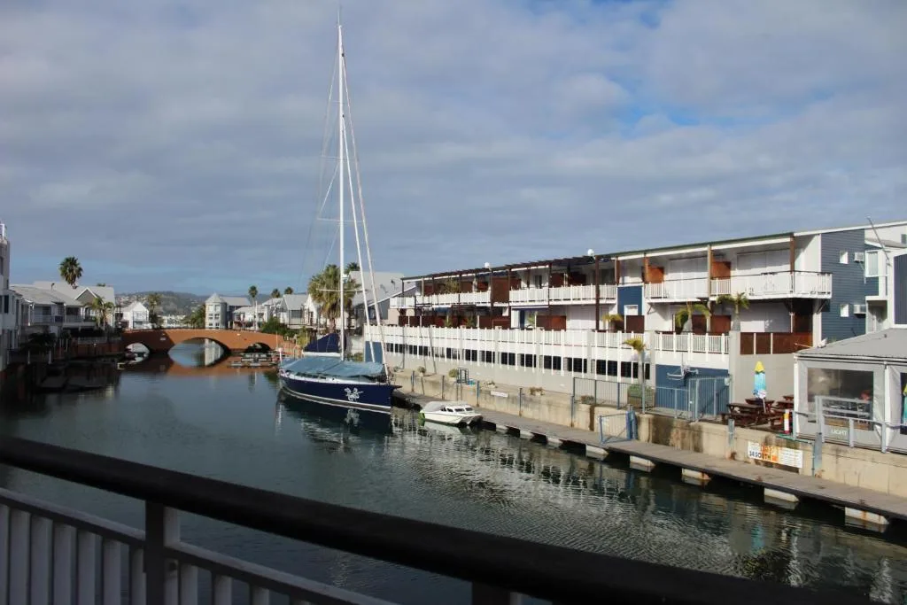 Waterfront view of Knysna Quays with sailboat and lagoon architecture