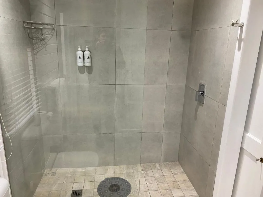Modern walk-in shower with glass enclosure and premium toiletries