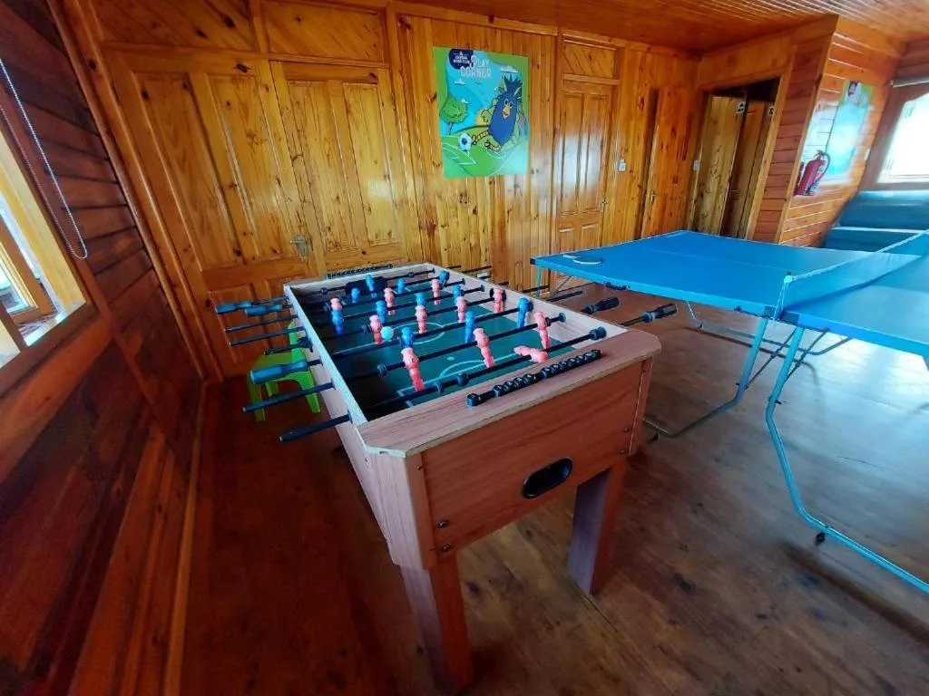 Wooden recreation room with foosball table and blue ping pong table