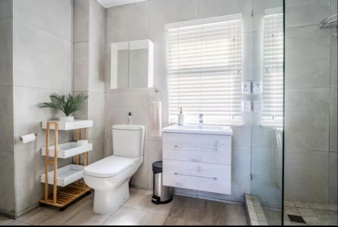 Modern bathroom with vanity, toilet, shower enclosure and natural light
