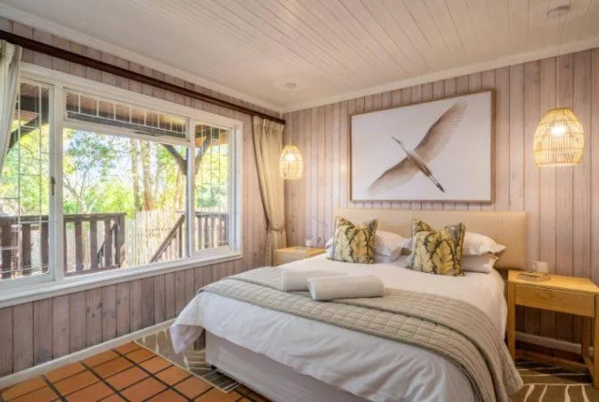 Spacious bedroom with queen bed, deck access, and modern decor