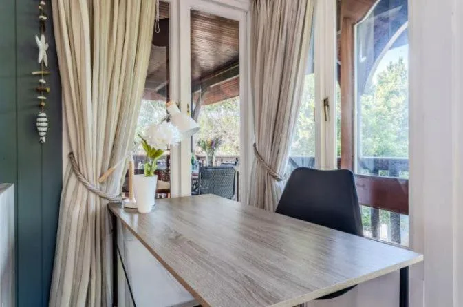 Waterfront deck with dining table overlooking Knysna lagoon and gardens