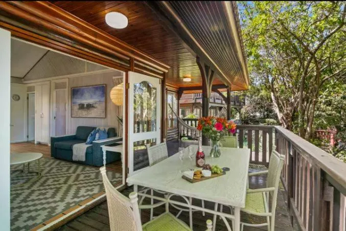 Covered deck with dining table overlooking garden and trees