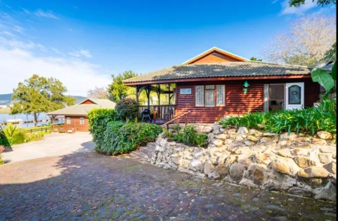 Red-brick waterfront chalet with covered porch and manicured gardens