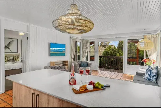Modern open-plan kitchen with white counters and coastal decor