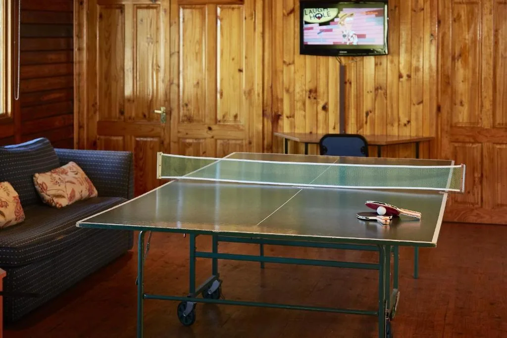 Recreation room with ping pong table, sofa, and mounted television