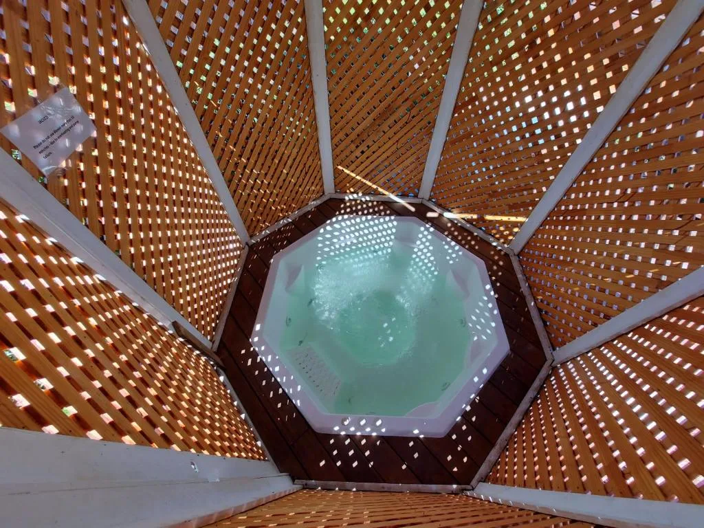 Indoor heated swimming pool viewed from above through wooden lattice ceiling