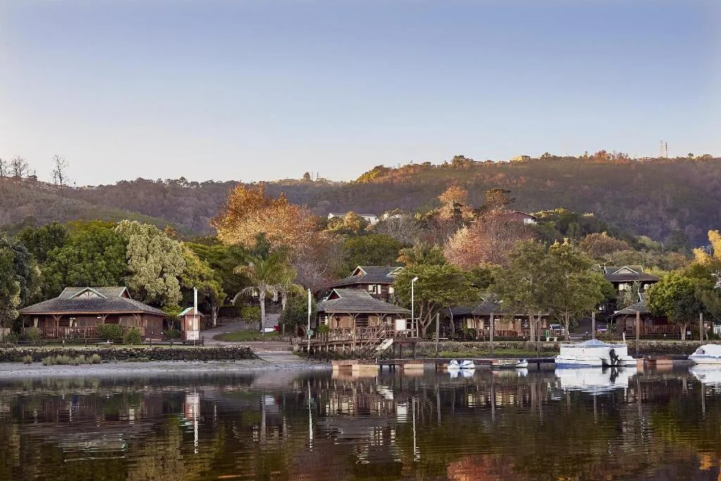 Riverside properties with boats moored on calm Knysna lagoon waters