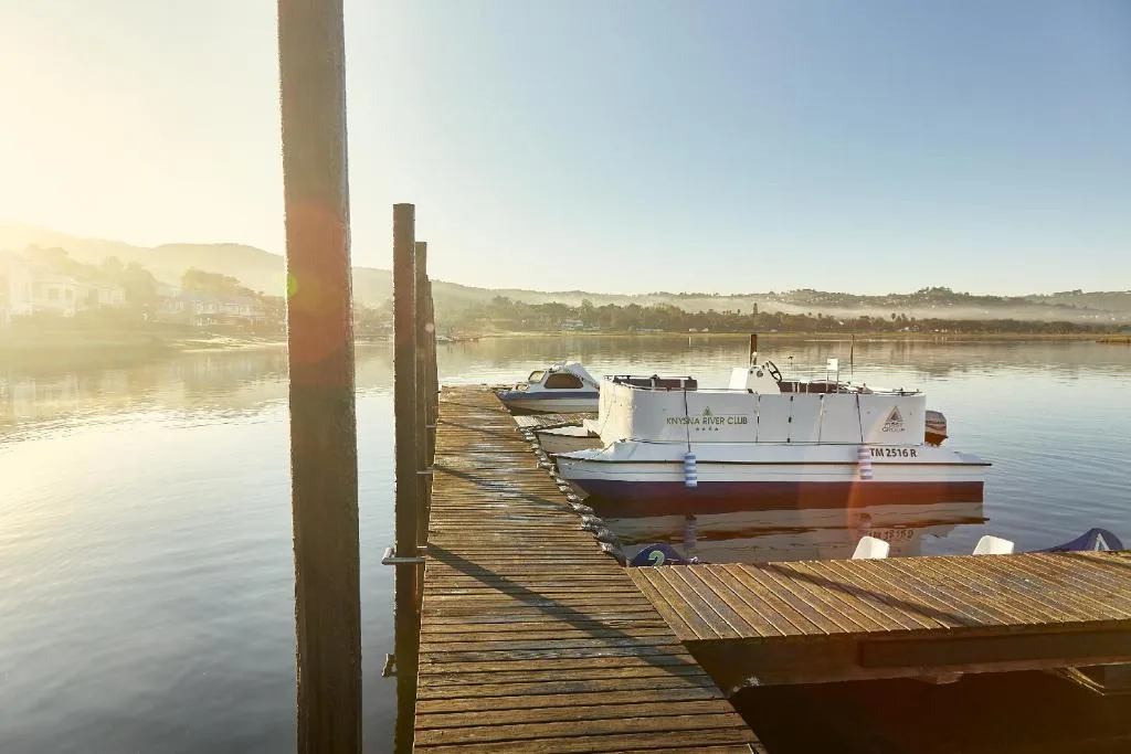 Serene morning view of moored boats on calm Knysna River with mountains
