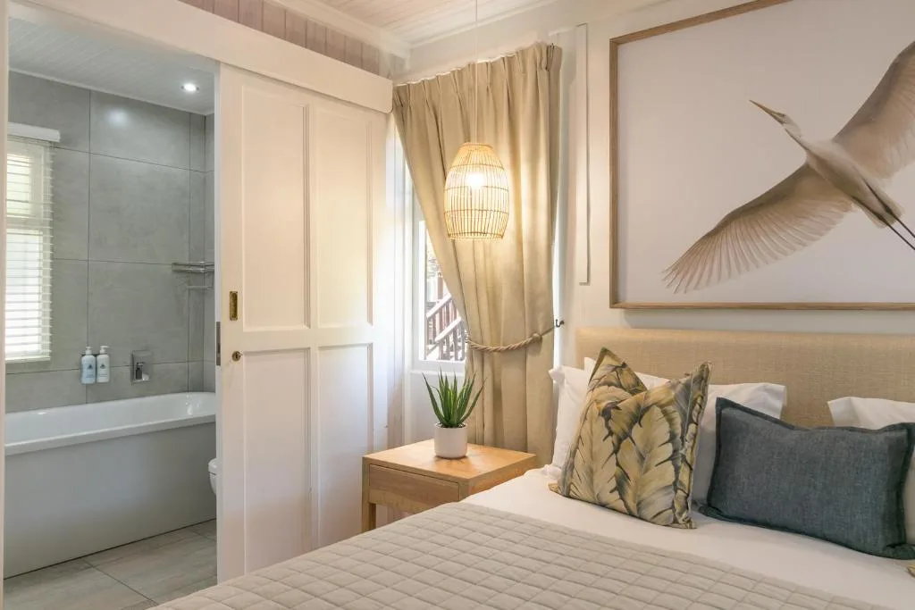 Spacious bedroom with en-suite bathroom, modern décor, and natural light