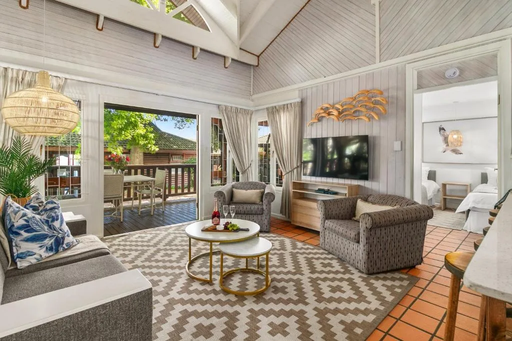 Spacious open-plan lounge with TV, comfortable seating, and deck views