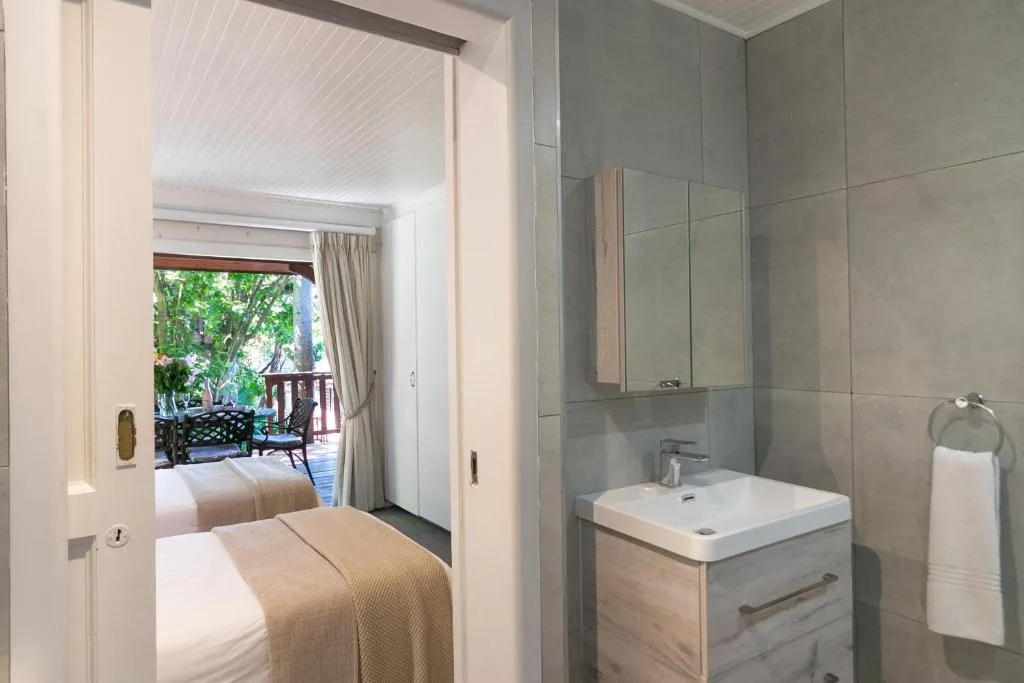 Modern ensuite bathroom with vanity, mirror cabinet, and tiled shower area