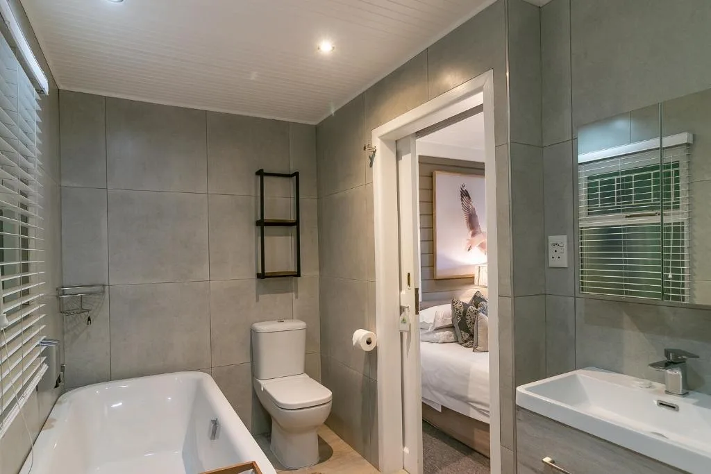 Modern bathroom with bathtub, toilet, vanity sink, and walk-in shower