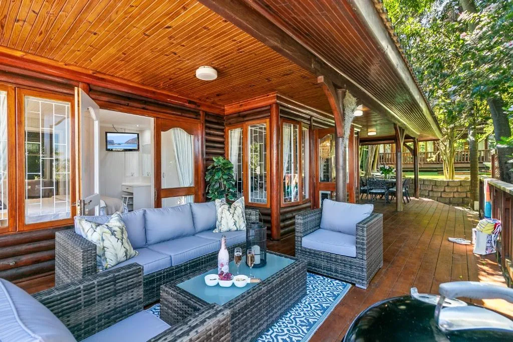Covered wooden deck with comfortable seating and garden views