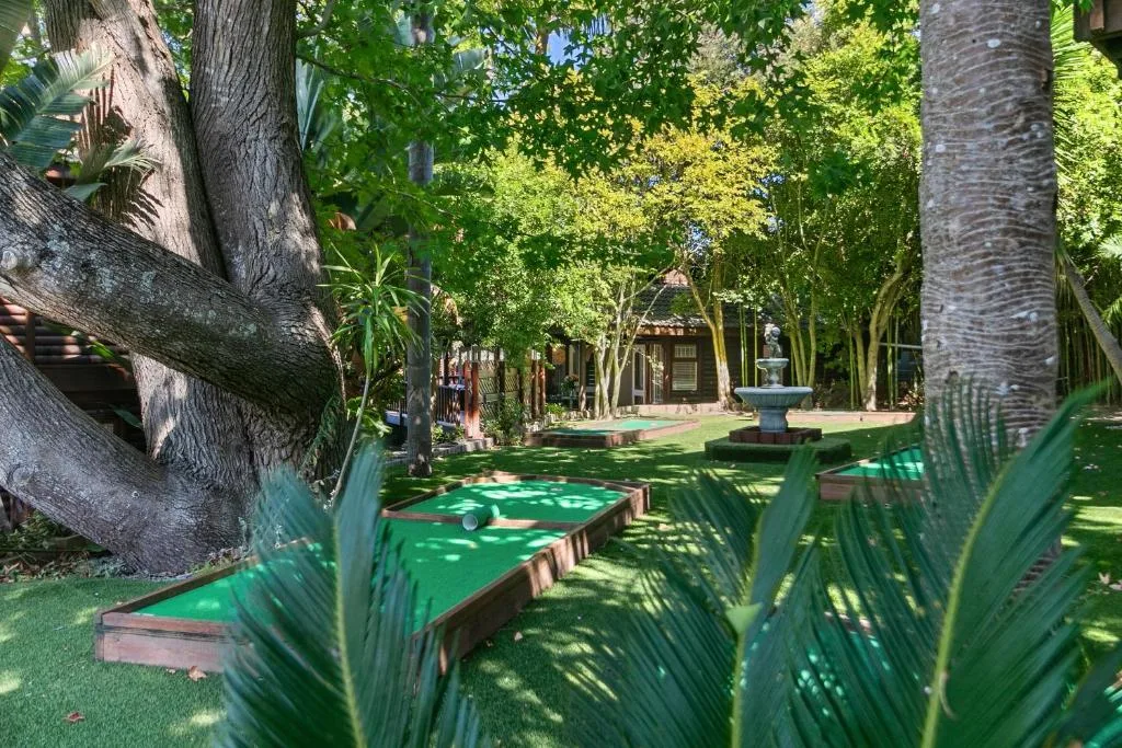 Lush garden with mini golf course and mature trees, property amenities