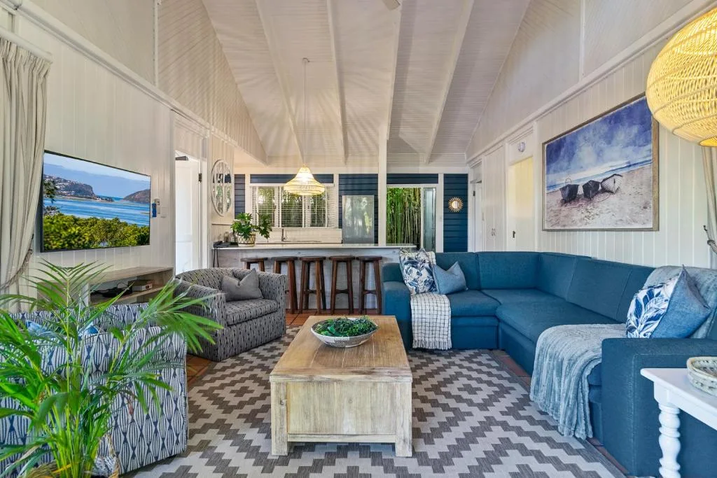 Spacious open-plan lounge with blue sectional sofa and coastal décor