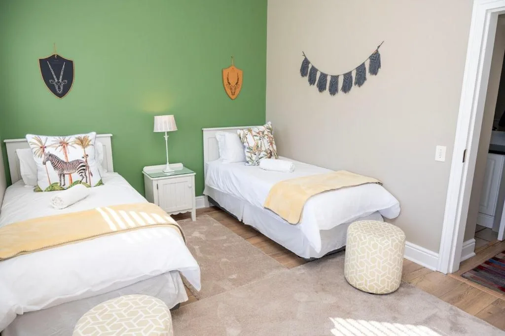 Bright twin bedroom with safari-themed decor and soft yellow accents