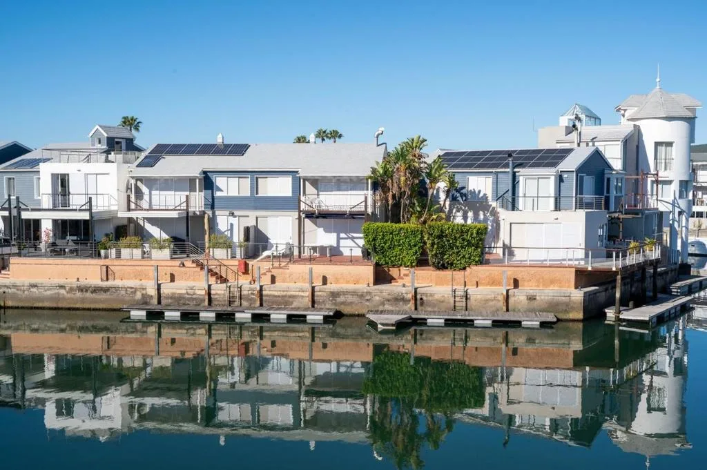 Waterfront properties with modern architecture reflected in calm lagoon water