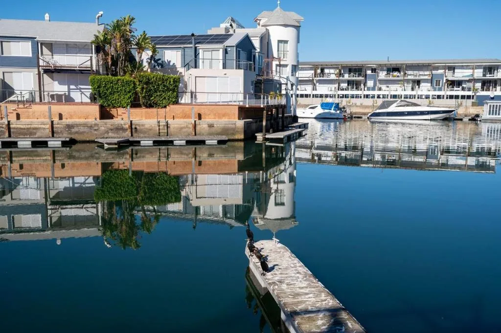 Waterfront property with lagoon views, moored boats, and charming architecture