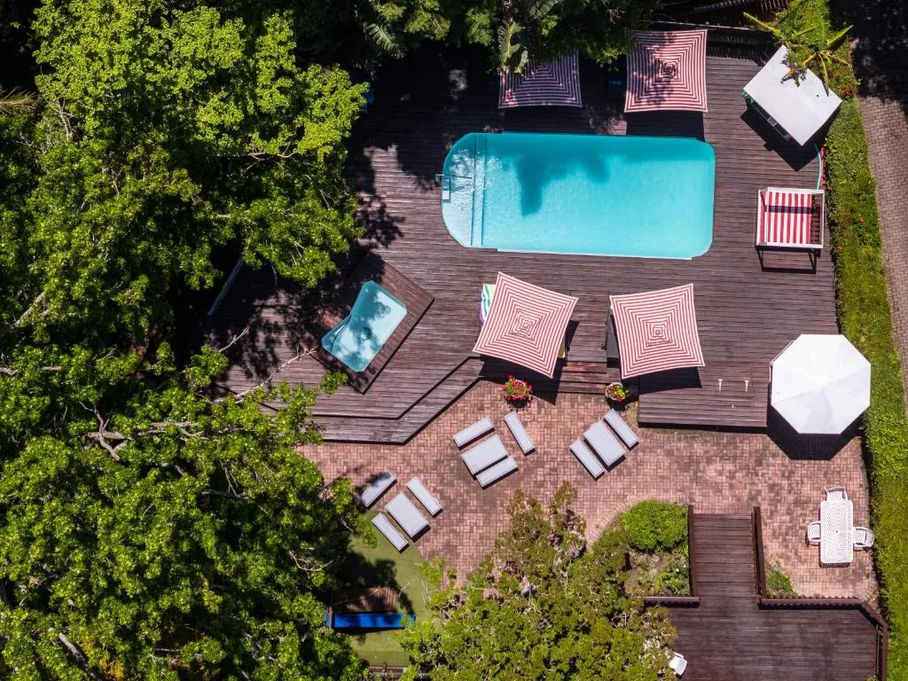 Aerial view of turquoise swimming pool surrounded by wooden deck and loungers