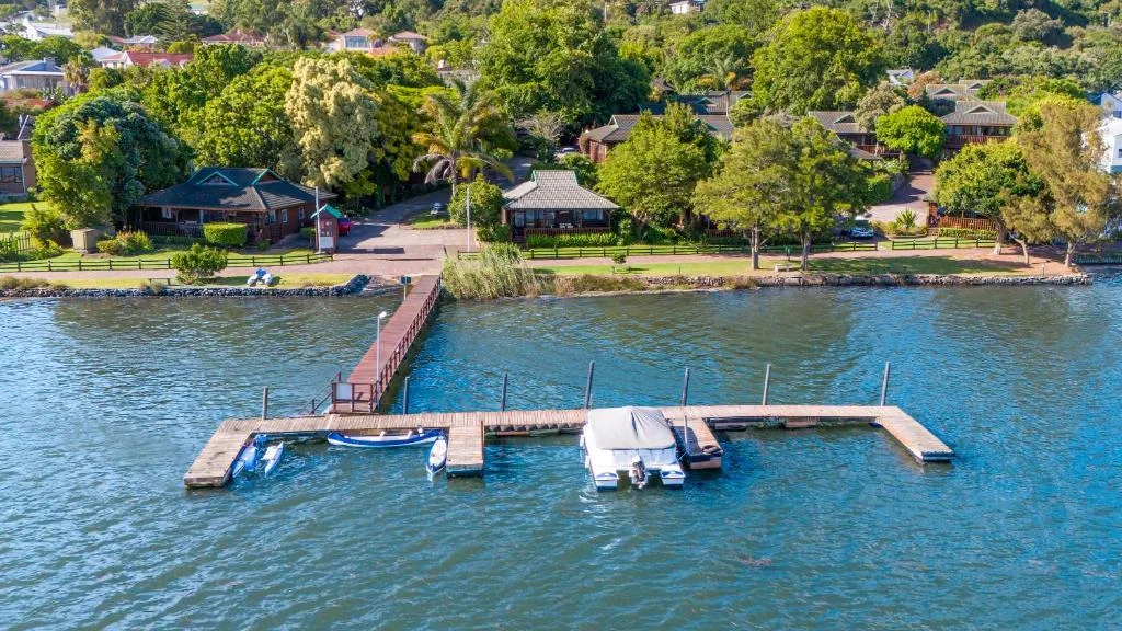Waterfront property with private jetty and moored boats on Knysna lagoon