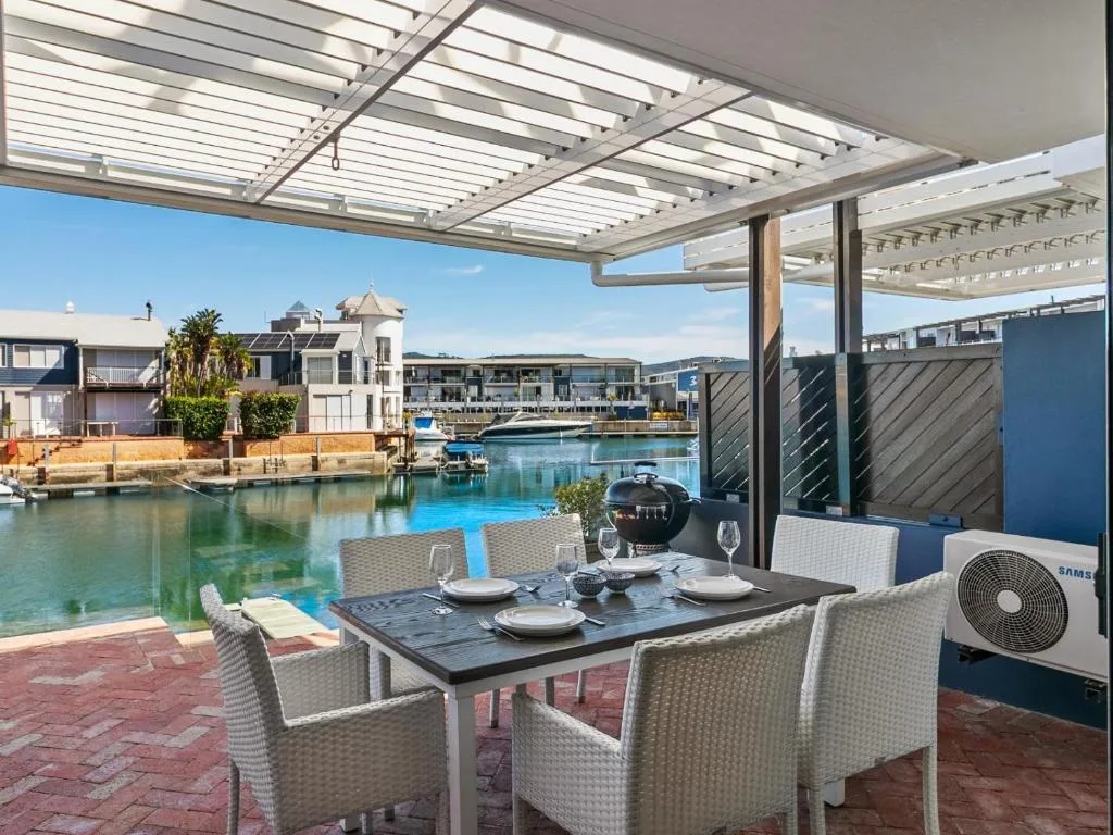 Waterfront dining area with pergola overlooking Knysna Quays marina