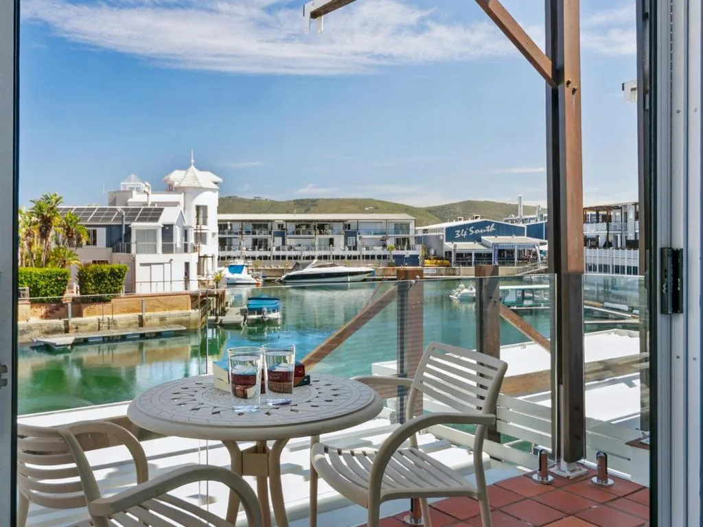 Waterfront deck with table and chairs overlooking Knysna Heads marina