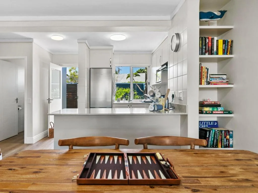 Open-plan kitchen and dining area with backgammon board on wooden table
