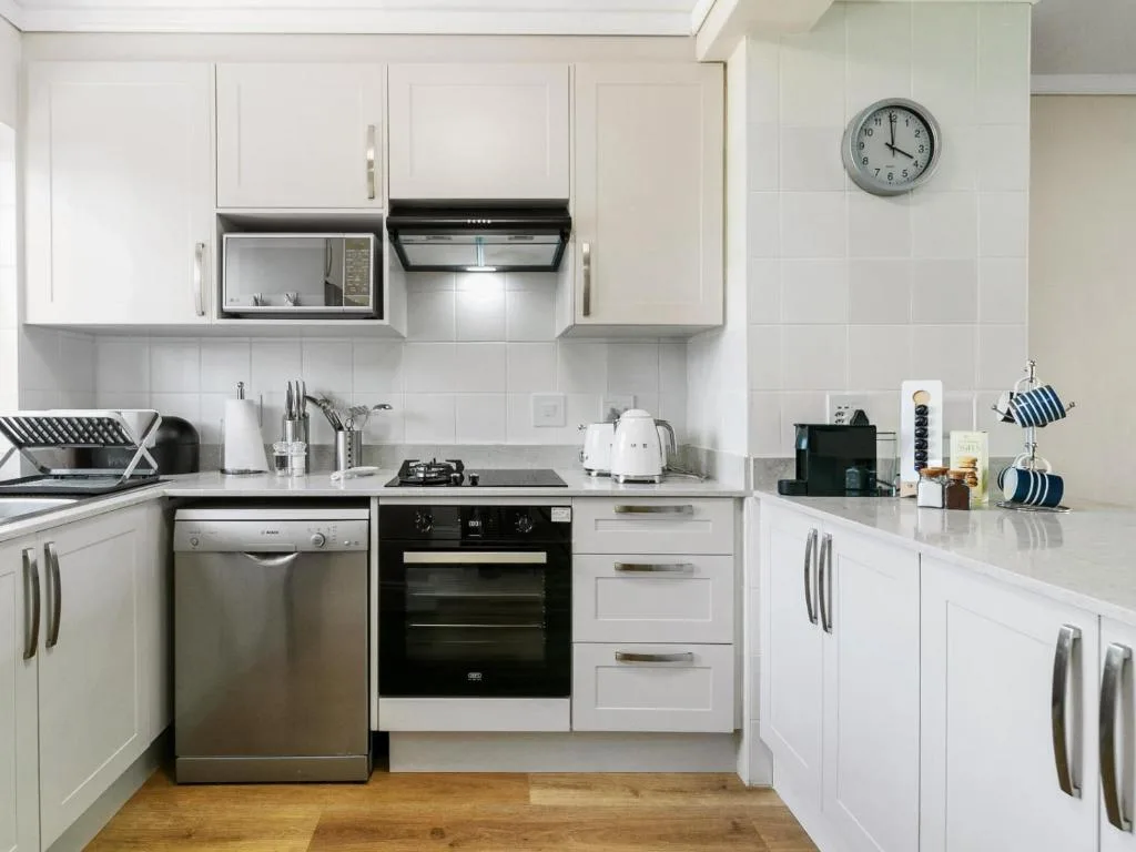 Modern white kitchen with stainless steel appliances and white cabinetry