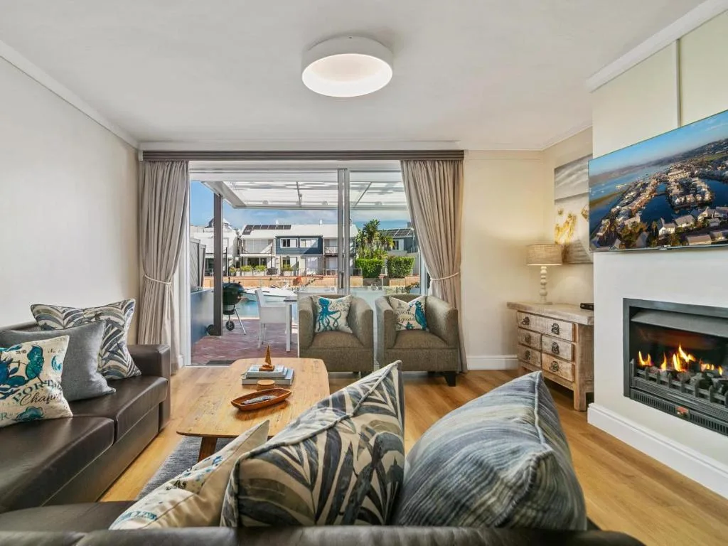 Spacious lounge with fireplace, comfortable seating, and pool view through glass doors