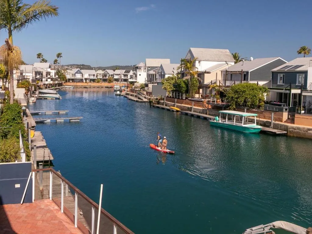 Waterfront lagoon view with moored boats and colorful residential architecture