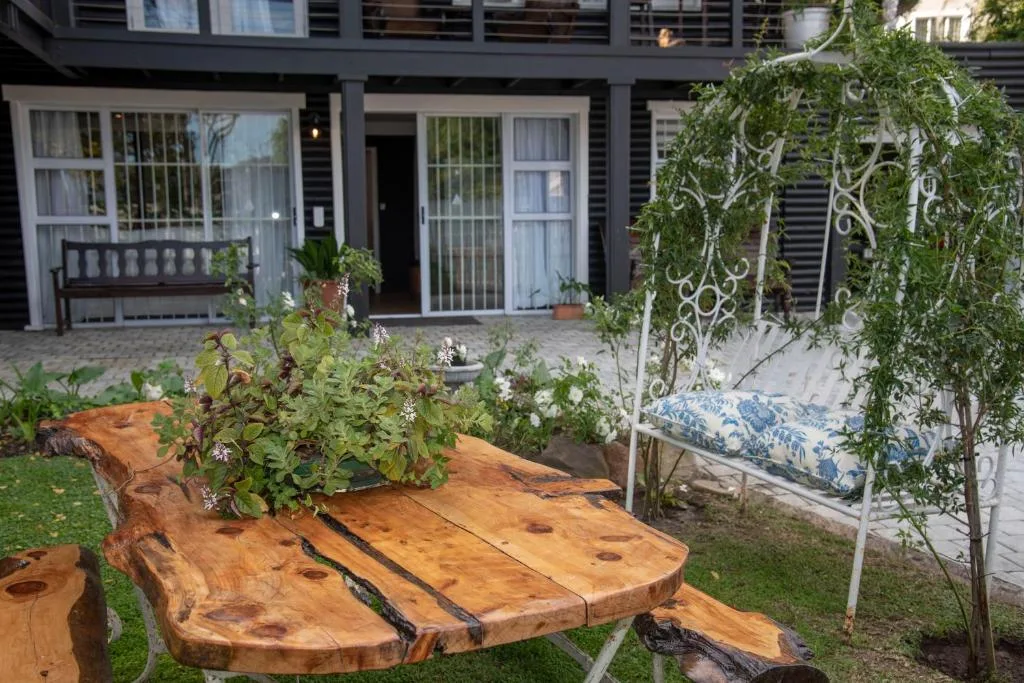 Rustic wooden table and seating area in landscaped garden courtyard