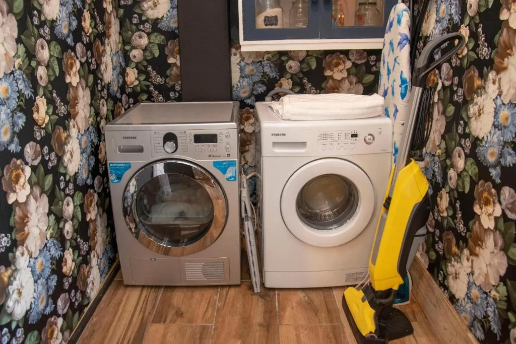 Laundry room with washer, dryer, and floral wallpaper