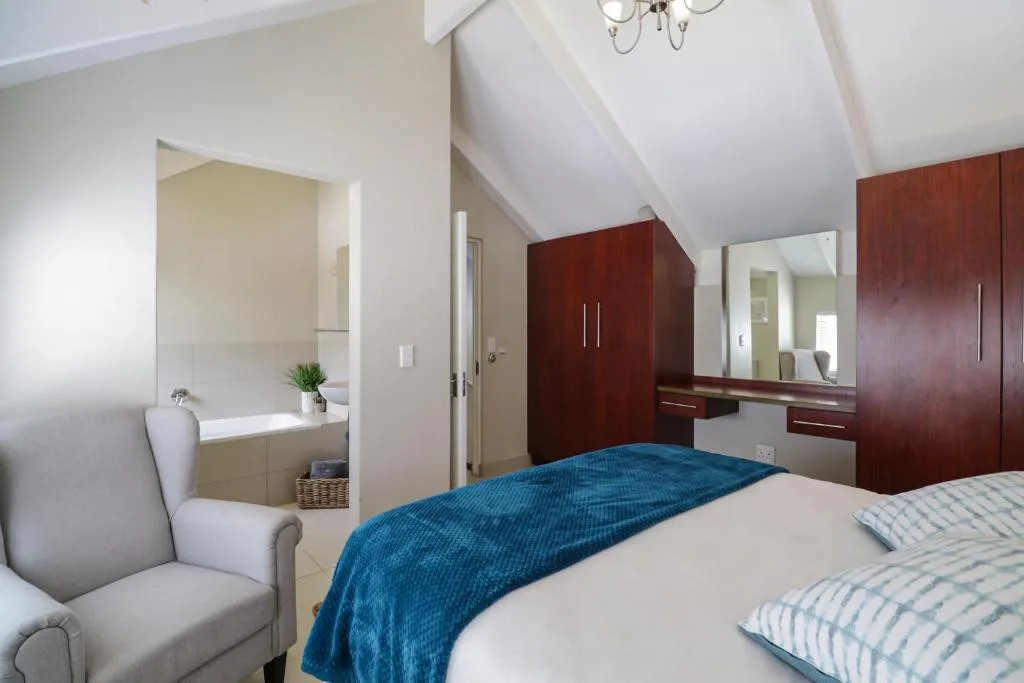 Spacious bedroom with twin beds, en-suite bathroom, and elegant furnishings