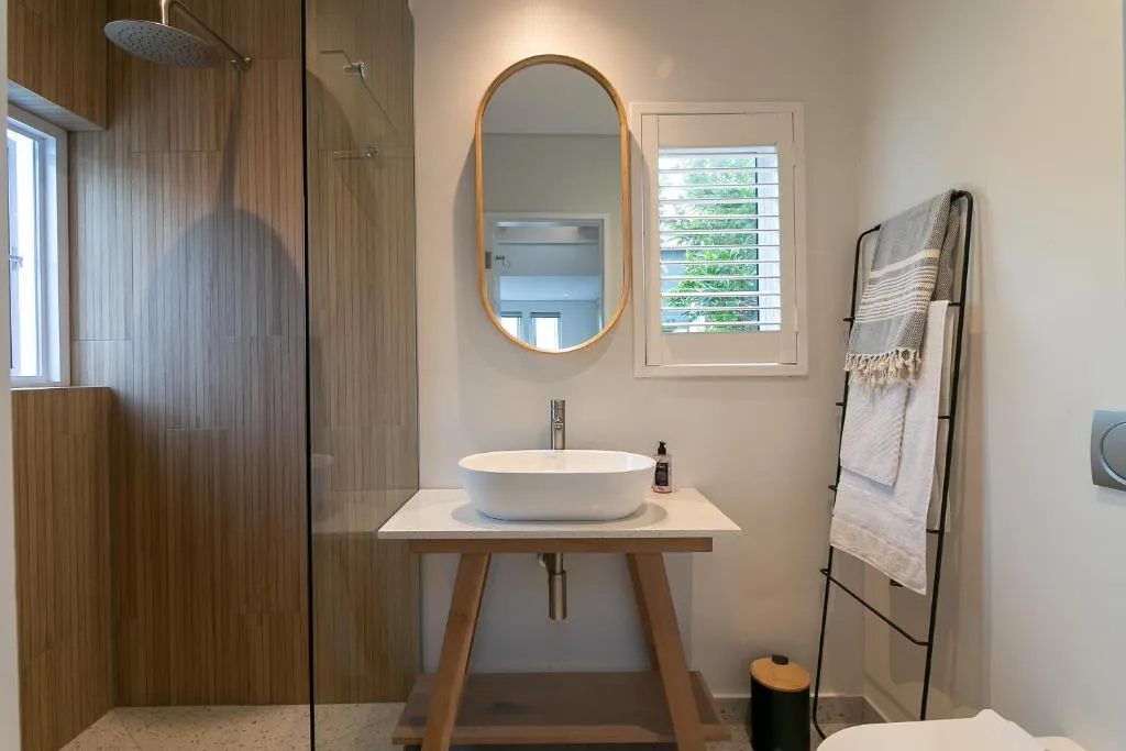 Modern bathroom with round white basin sink and wooden vanity