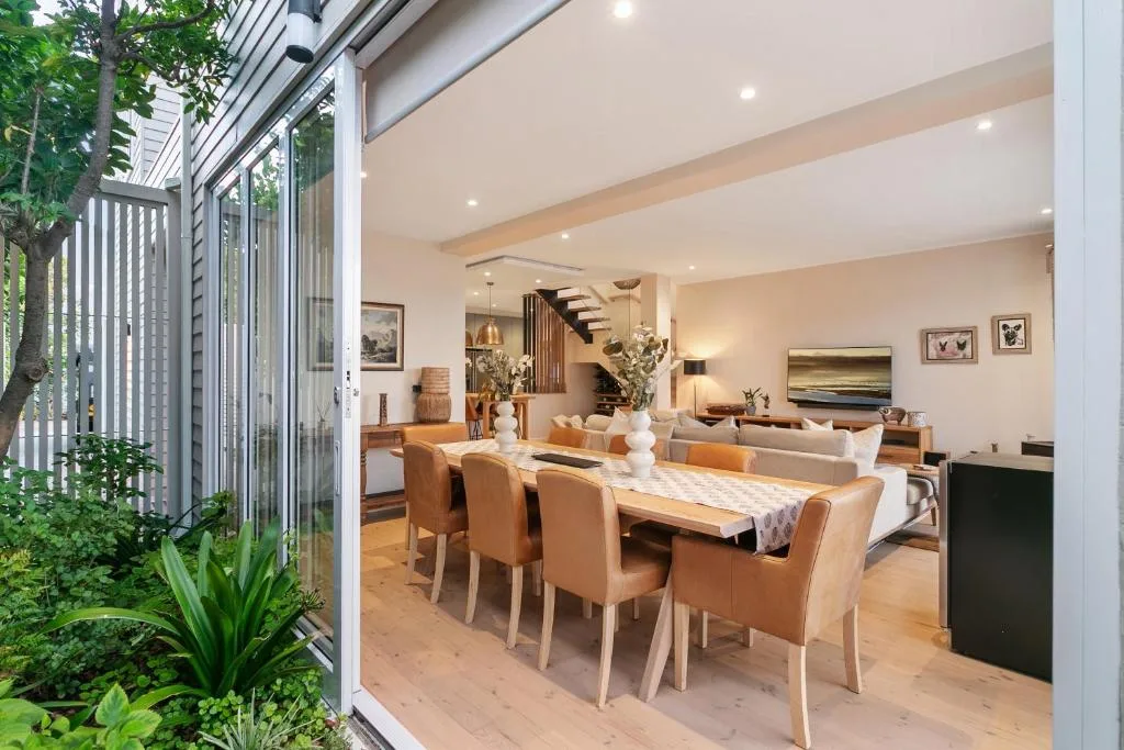 Open-plan dining area with marble table and leather chairs overlooking lounge