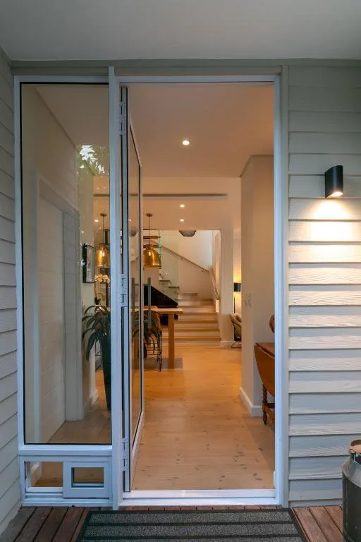Modern glass entrance doors opening into bright interior hallway