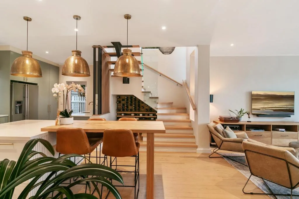 Open-plan living area with dining table, lounge seating, and modern copper pendant lighting