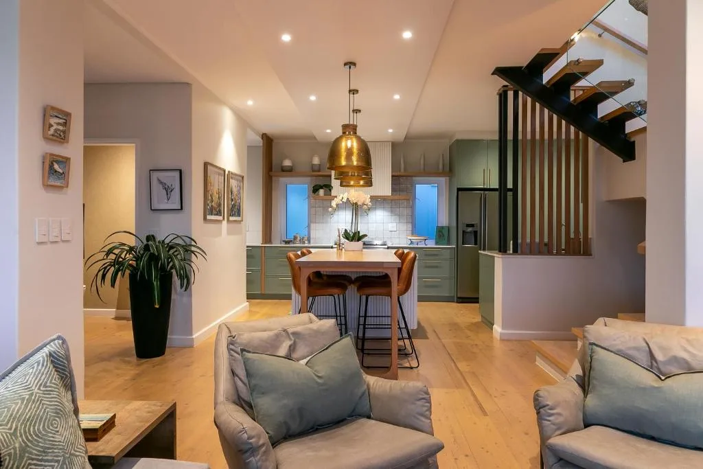 Open-plan living area with comfortable seating and modern kitchen visible beyond