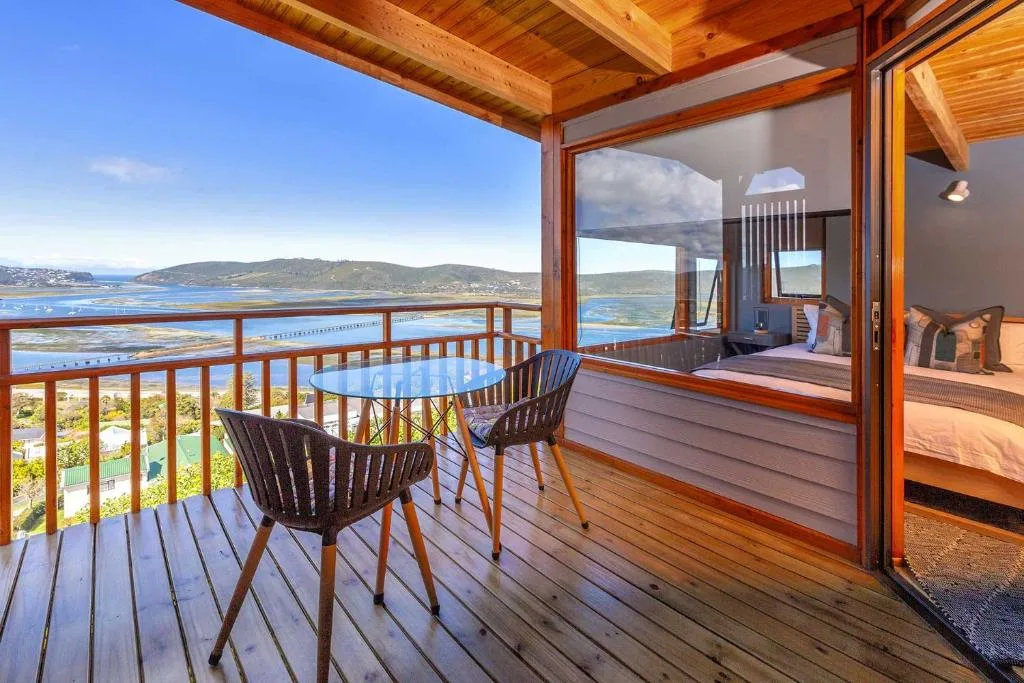 Wooden deck with table and chairs overlooking lagoon and mountains