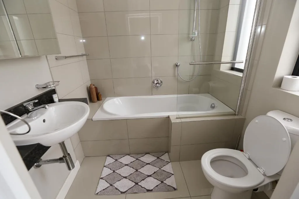 Clean modern bathroom with sink, bathtub, shower, and toilet
