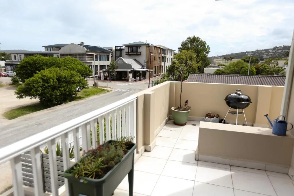 Spacious outdoor patio with braai grill and potted plants overlooking neighborhood
