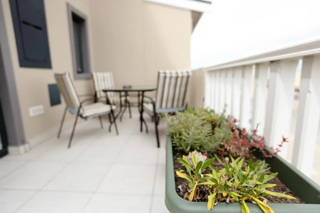 Outdoor patio with seating, planters, and garden views