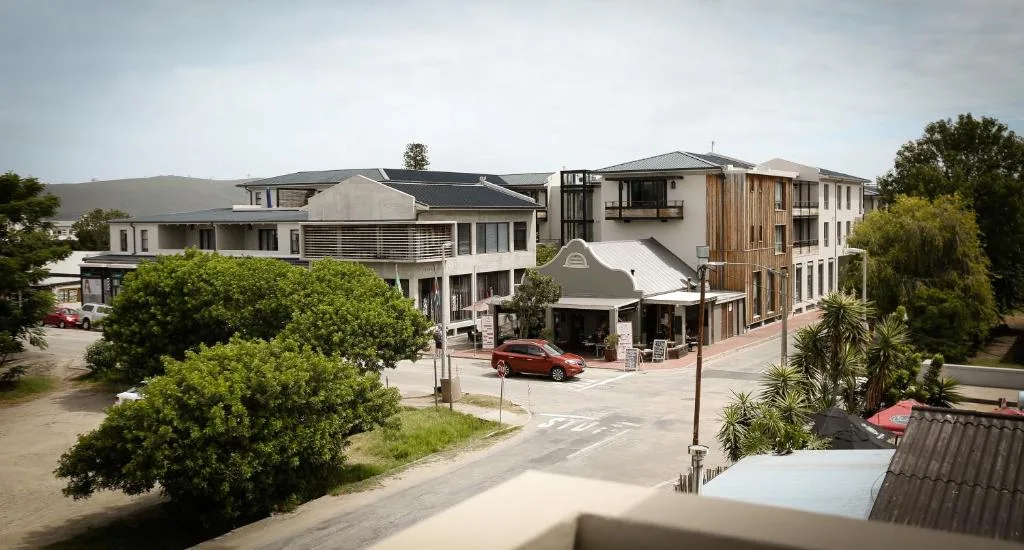 Modern multi-story residential complex with landscaped gardens and parking area