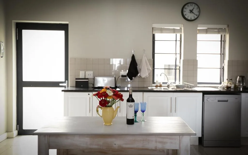 Modern kitchen with white cabinetry, island counter, and bright windows