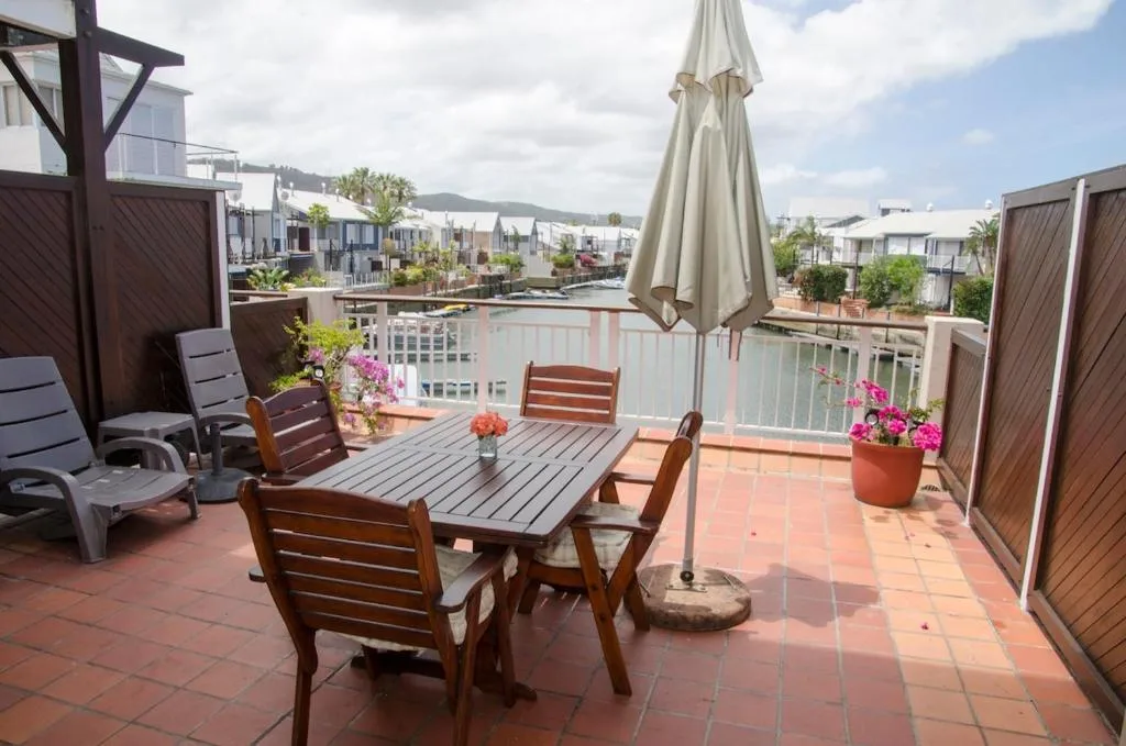 Spacious terracotta deck with dining table, lounge chairs, and mountain views