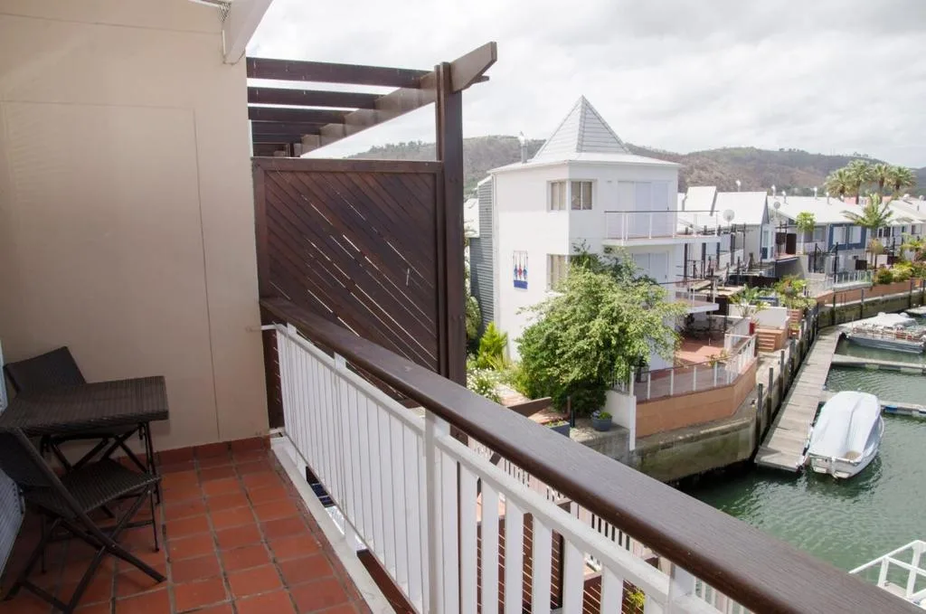 Waterfront balcony with pergola overlooking lagoon and boats